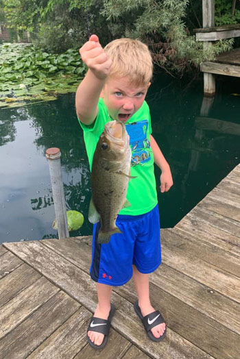This boy couldn't be prouder of the really big bass he caught!