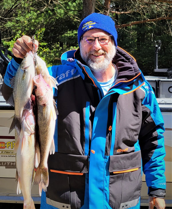 Walt wearing a blue jacket snap jigging walleye