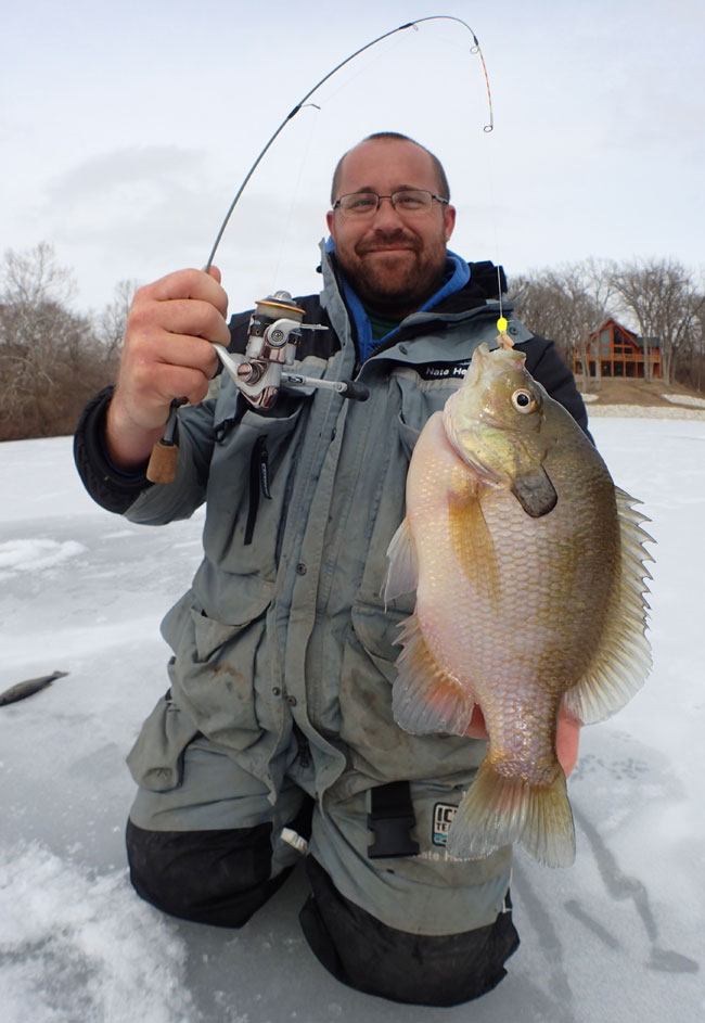 Nate is showing off his giant crappie while it is still on the hook